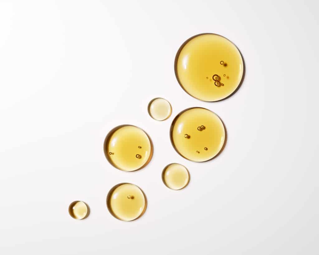 Gros plan haute résolution de gouttes d'huile liquide dorées