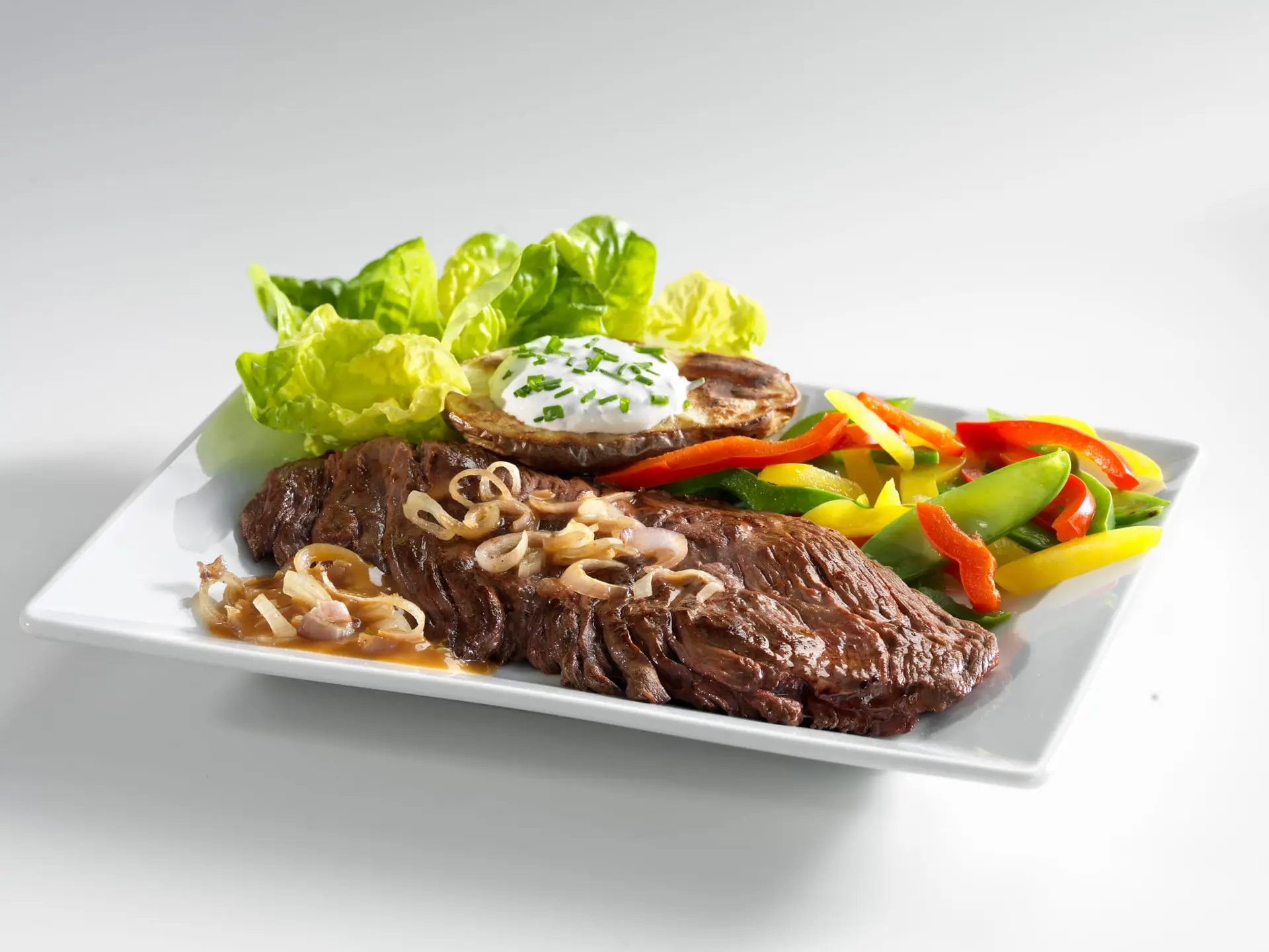 Bavette sauce aux oignons aux poivrons et pomme de terre rôtie