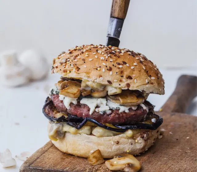 Burger au steak haché, aubergine, Roquefort et champignons de Paris
