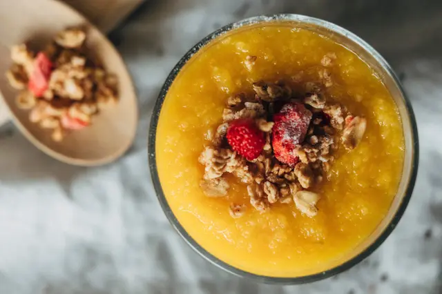 Compote de mangue avec granola et fraises des Alpes