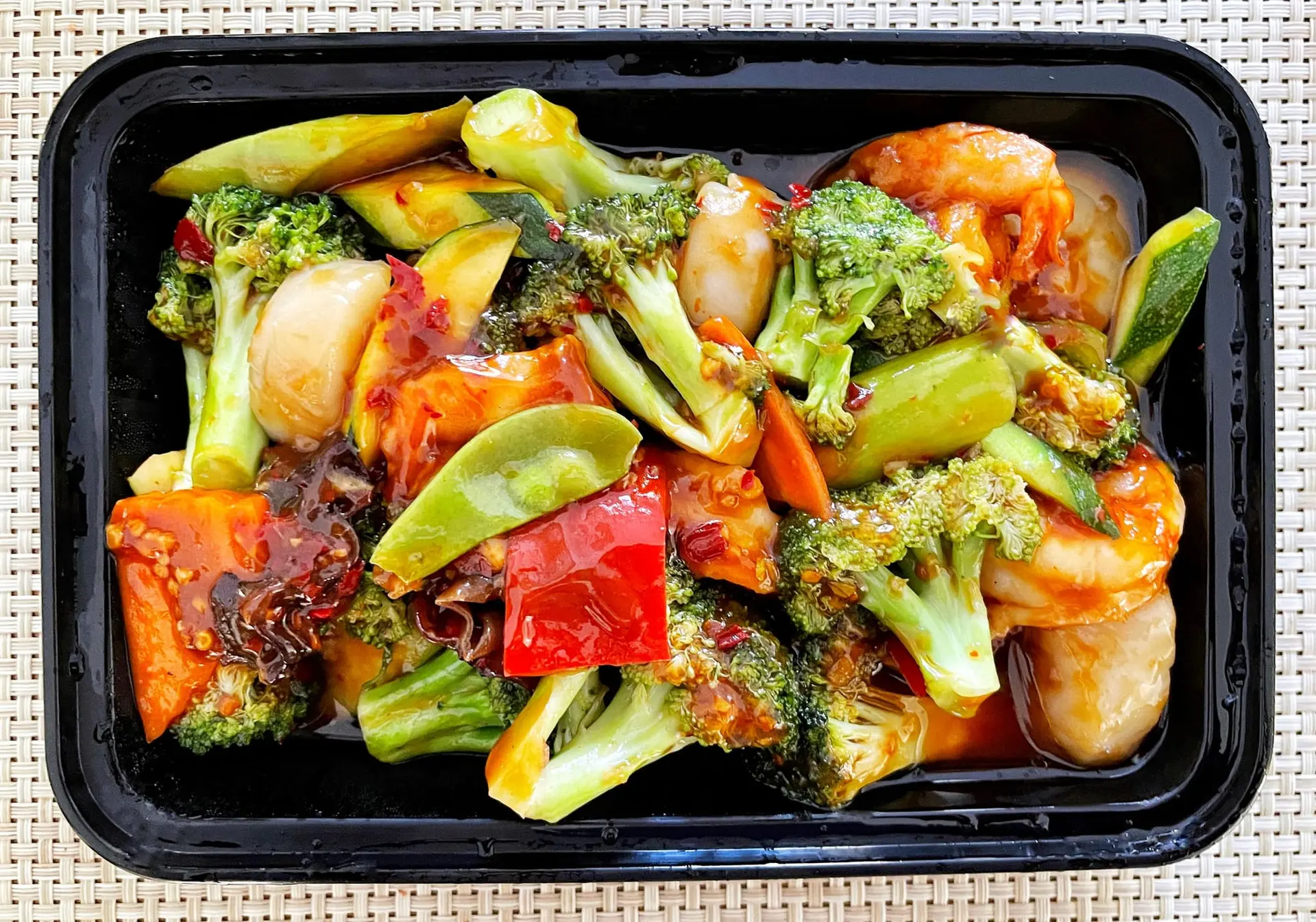 Crevettes, pétoncles et légumes mélangés dans une sauce à l’ail
