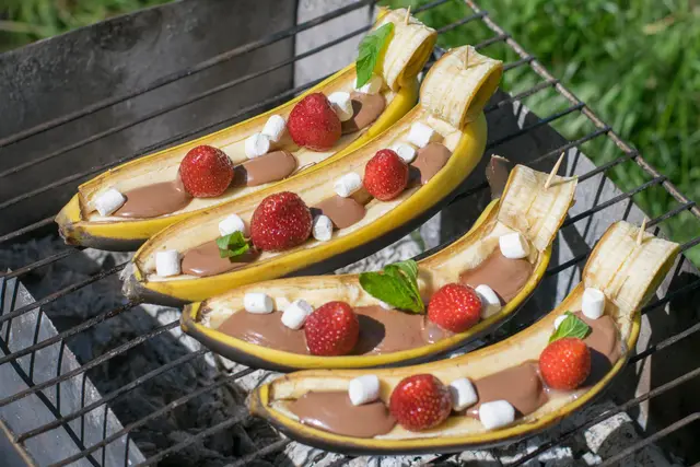 Demi bananes avec chocolat fraises et petites guimauves au barbecue