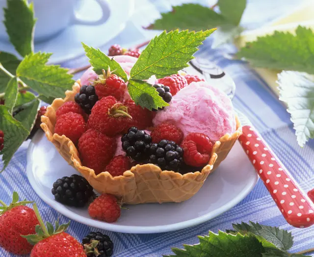 Framboises et mûres avec de la glace dans un bol gaufré