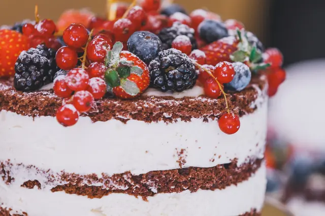 Gâteau nu au chocolat avec crème fouettée décoré de baies