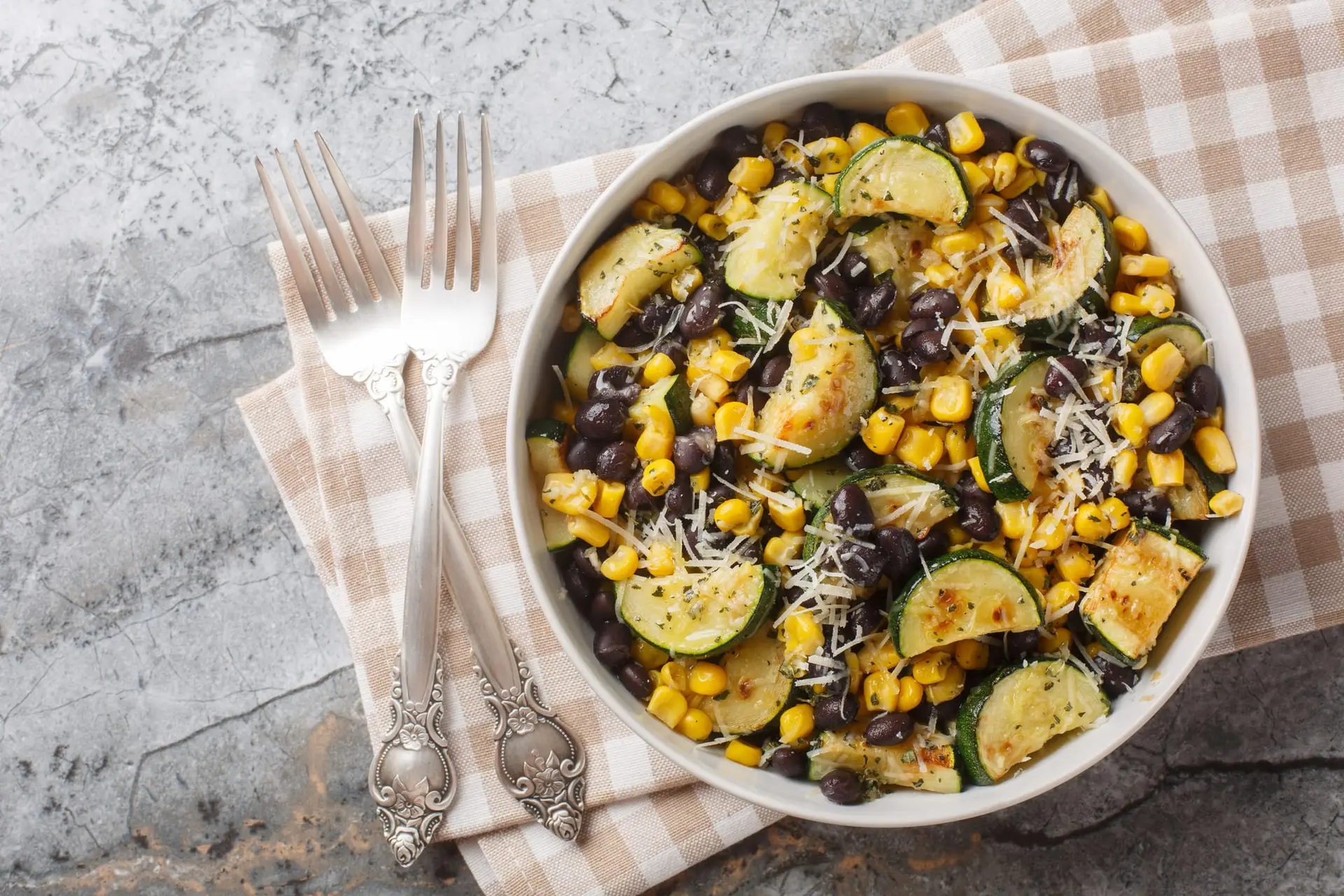 Salade de courgettes rôties avec des haricots noirs, du maïs, de l’ail et du fromage