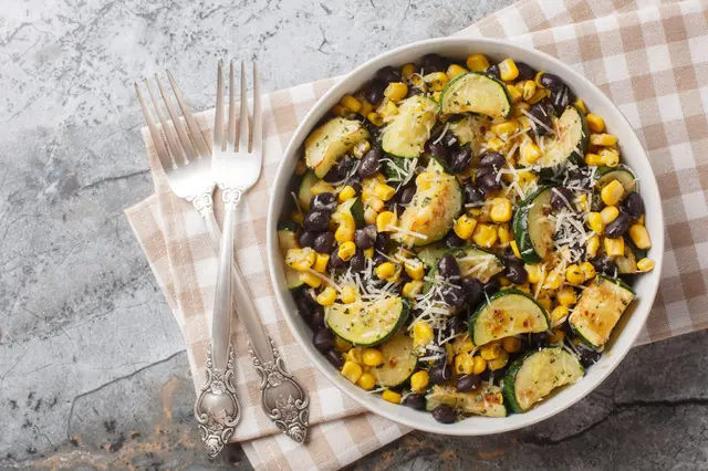 Salade de courgettes rôties avec des haricots noirs, du maïs, de l’ail et du fromage