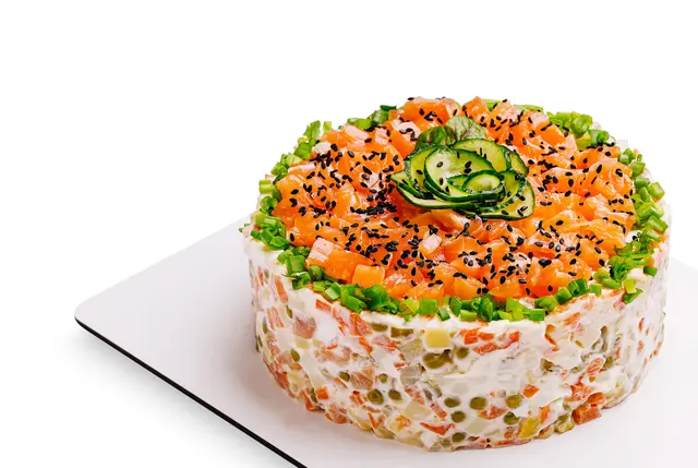 Gâteau coloré aux légumes et au saumon garni de tranches de concombre