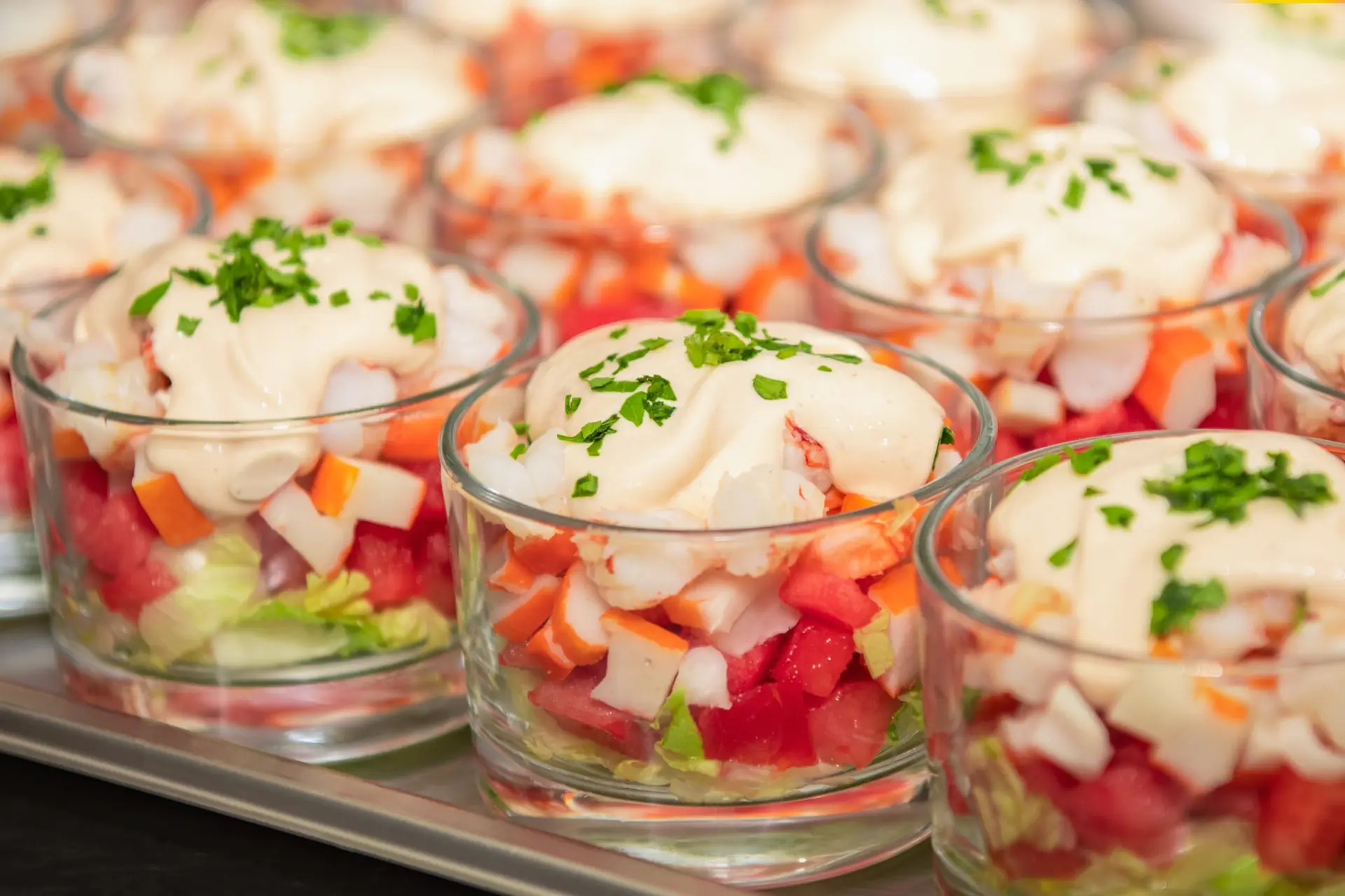Verrine de crevettes hachées avec pastèque, bâton de crabe, laitue, sauces roses et persil