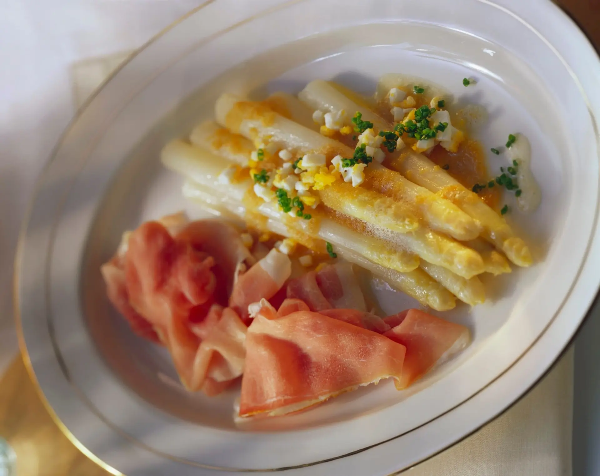 Asperges blanches à la sauce aux œufs, ciboulette et jambon
