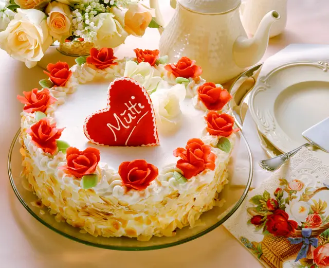Gâteau à la crème blanche décoré de roses en pâte d'amande rouge pour la fête des mères