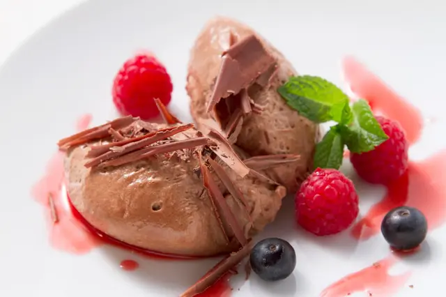 Mousse au chocolat garnie de fruits rouges frais et de menthe