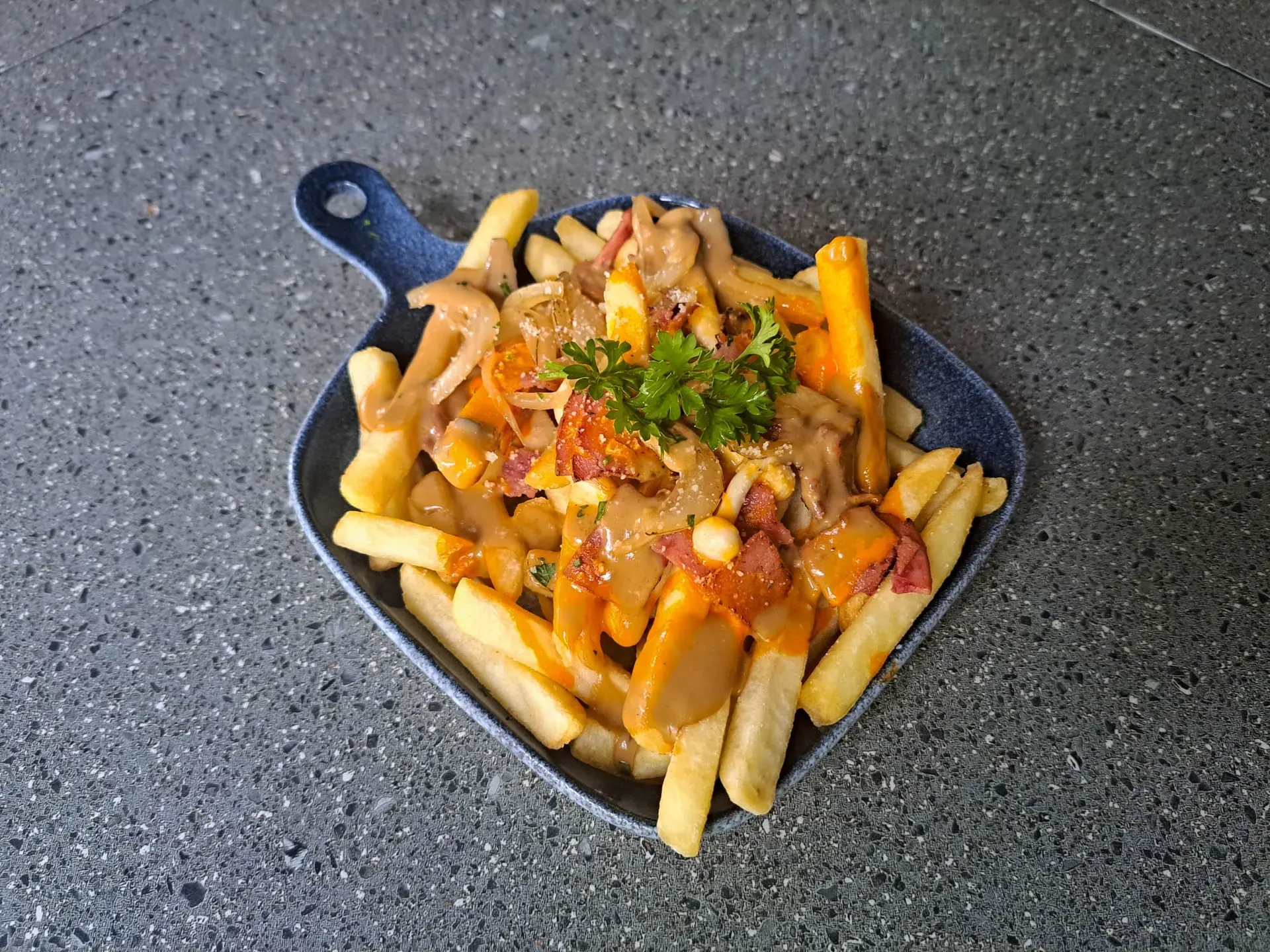 Poutine au bœuf fumé, champignons, caramel à l’oignon, parmesan et sauce noisette
