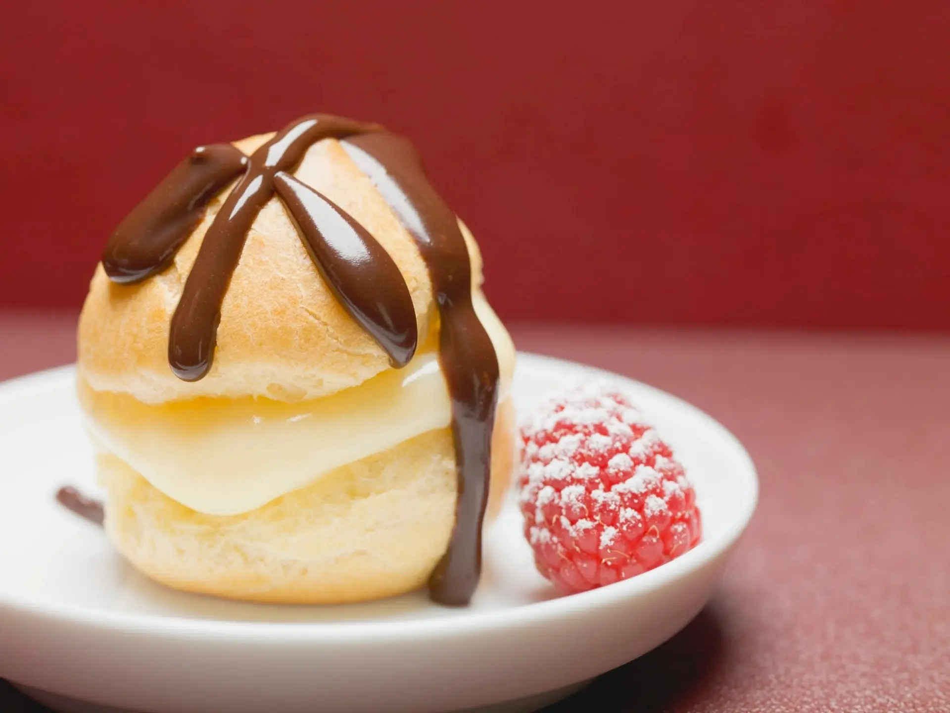 Profiterole à la crème vanillée, chocolat et framboises