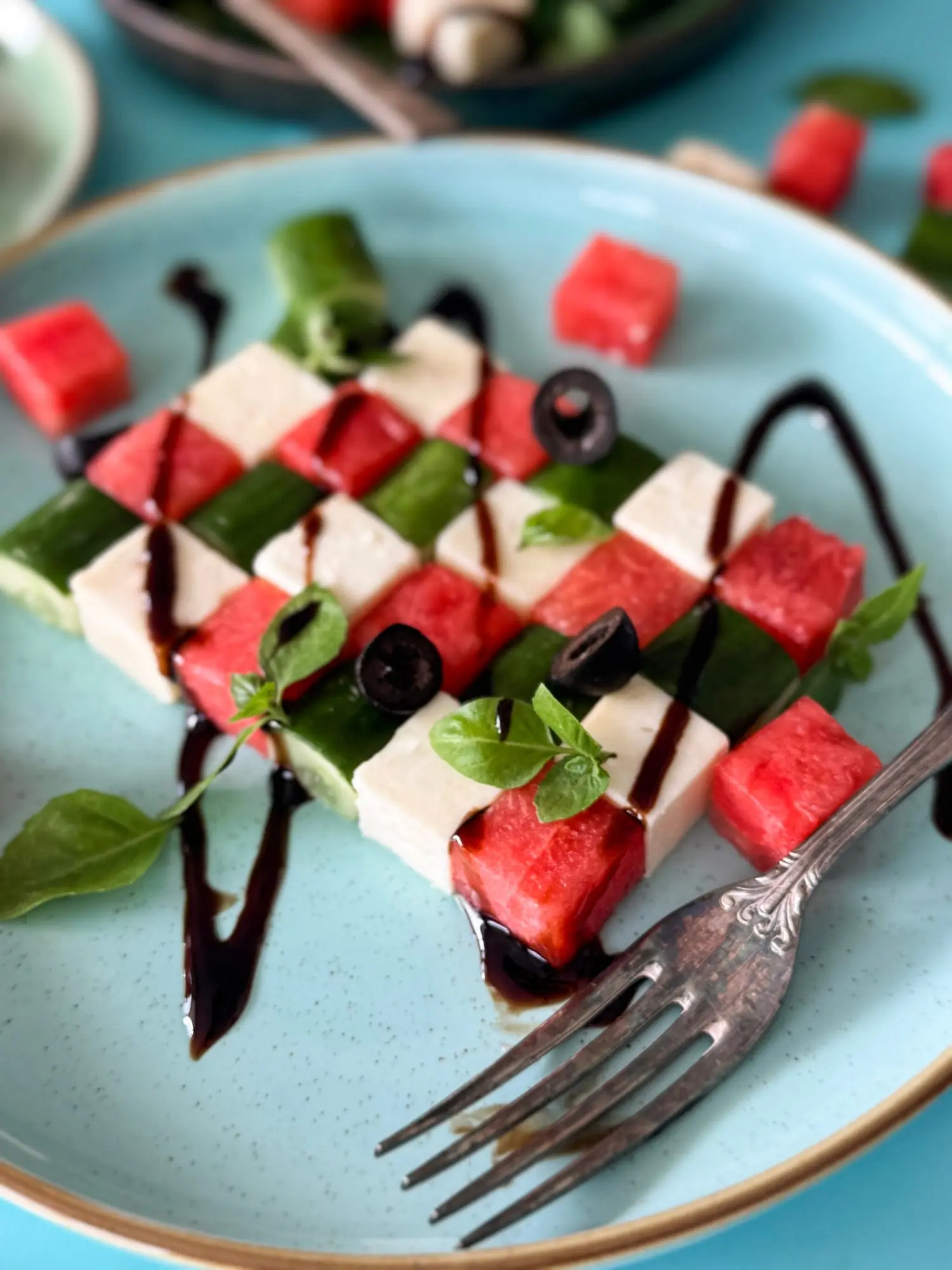 Salade de pastèque, de feta et de concombre, garnie de tranches d’olives noires