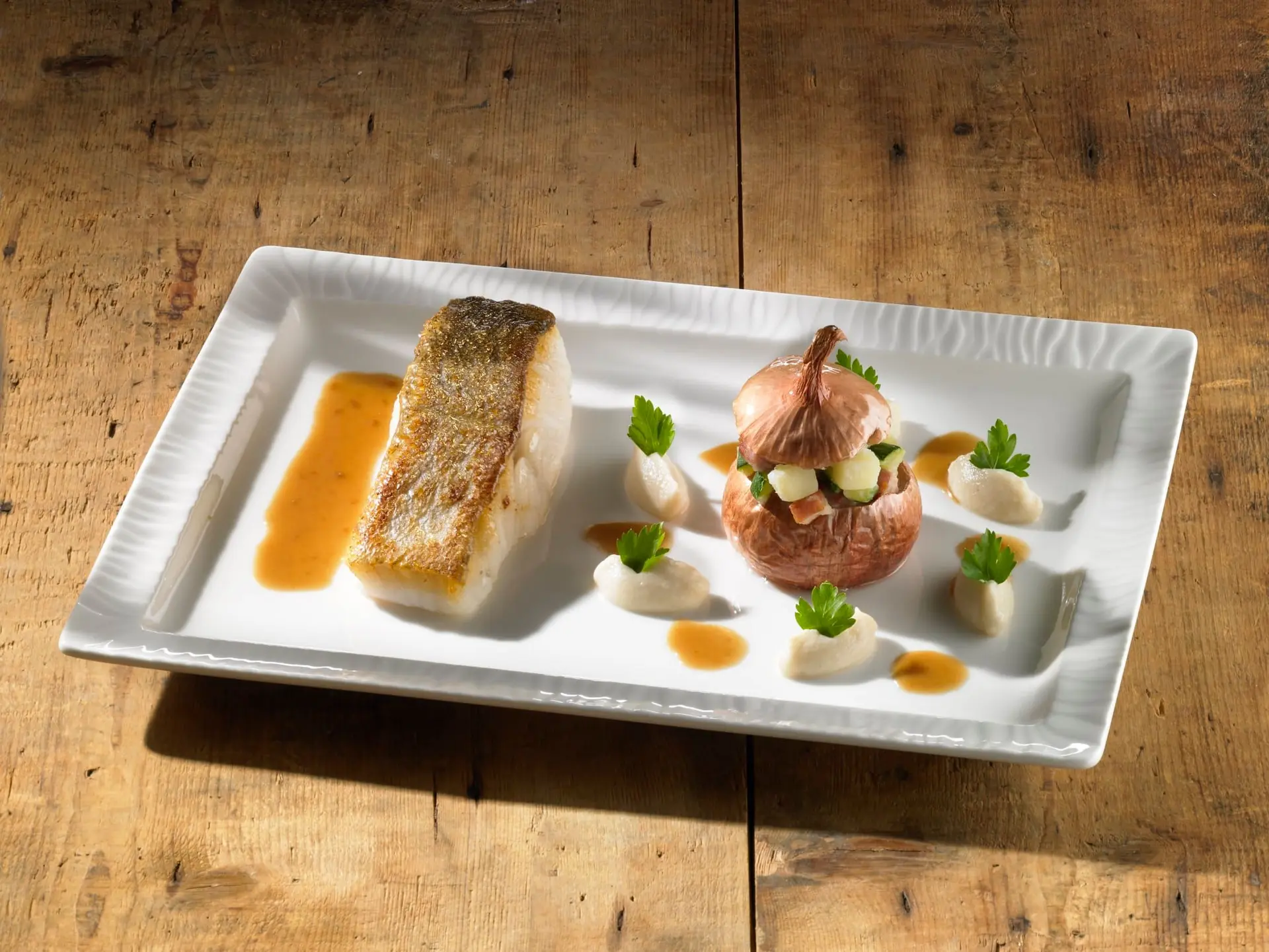 Pavé de lieu jaune et oignon farci aux légumes et au lard, quenelles de purée de céleri, sauce cognac