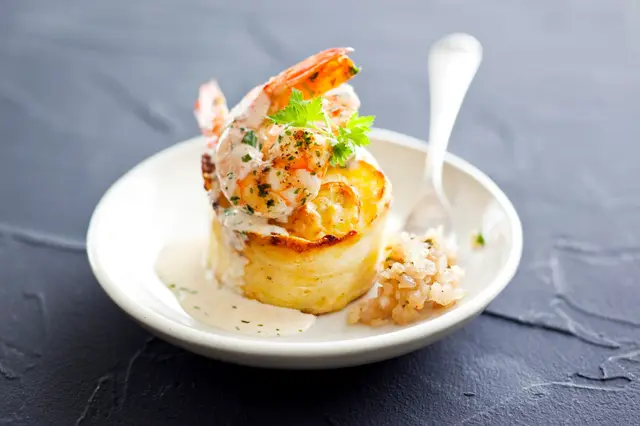 Gratin de pommes de terre aux gambas rôties, sauce crémeuse