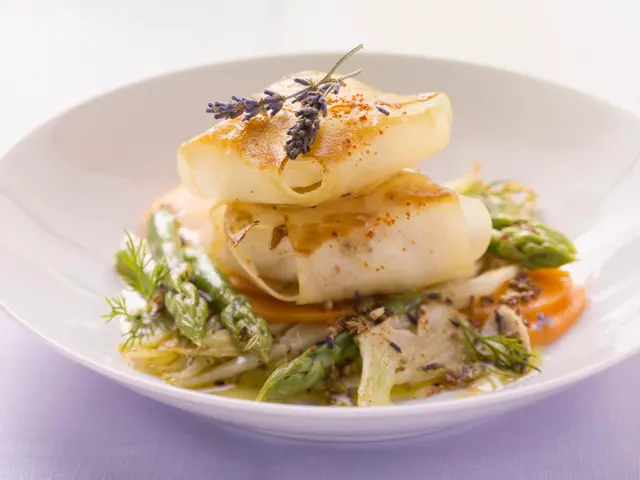 Lotte enrobée de pommes de terre sur un mélange de fenouil et d'asperges