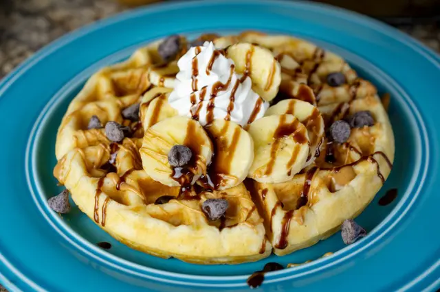Gaufre avec bananes, beurre de cacahuète, filet de sirop de chocolat et pépites de chocolat