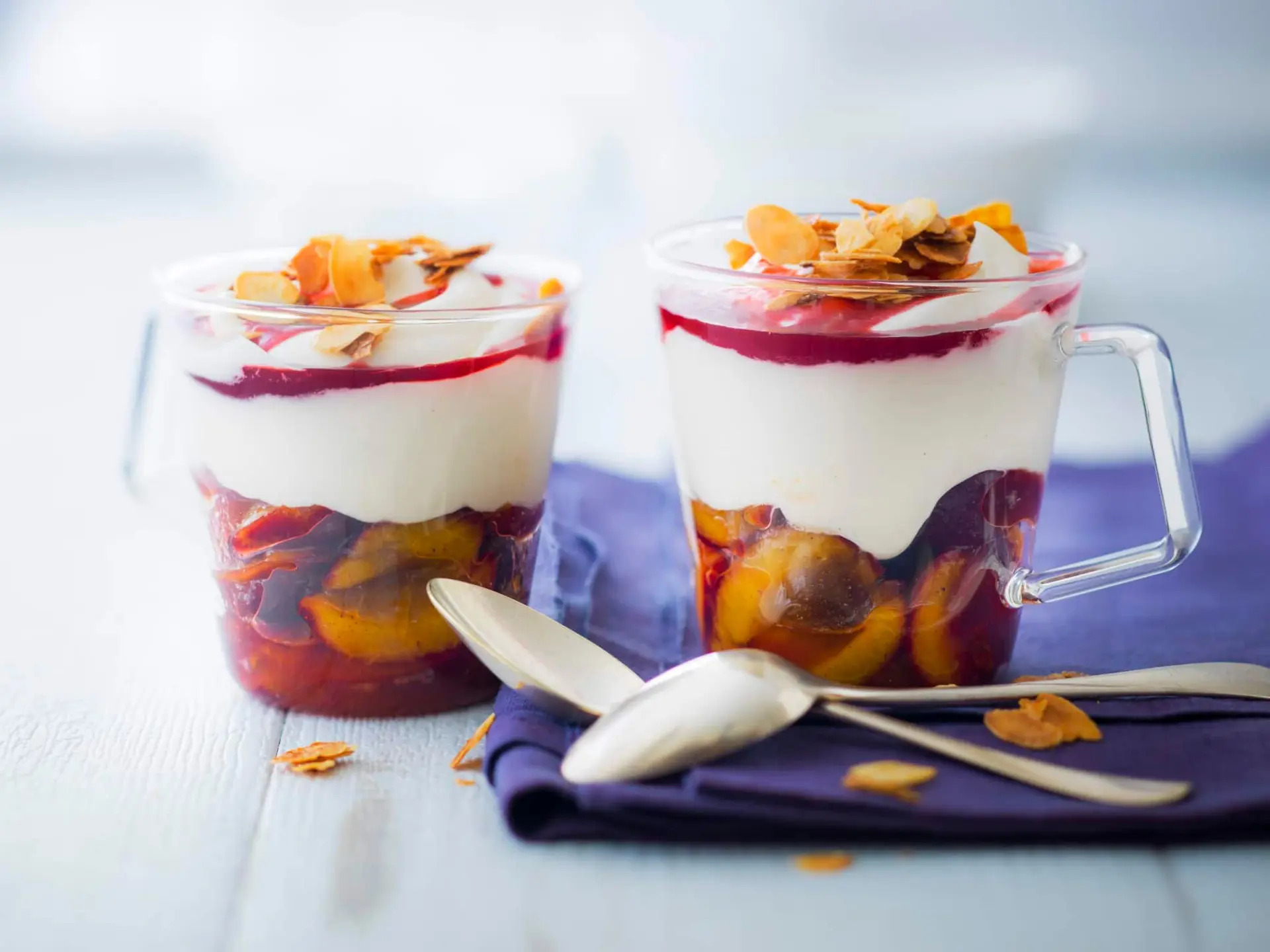 Coupe crémeuse aux quetsches en sirop, coulis de groseilles et amandes effilées caramélisées