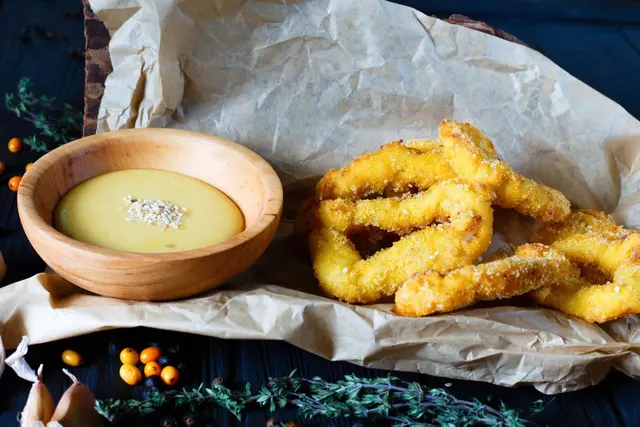 Anneaux d’oignon frit panés avec sauce crémeuse