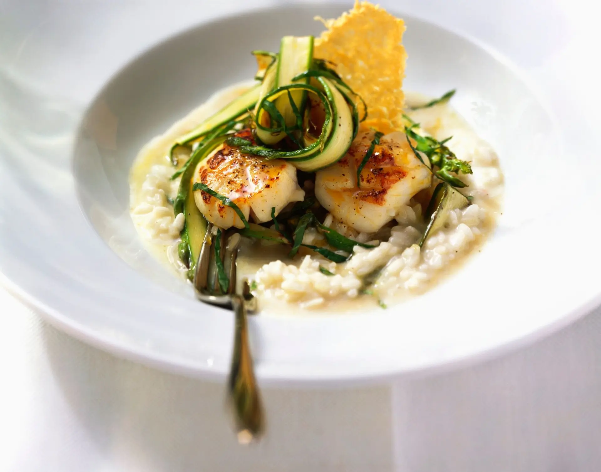 Noix de Saint-Jacques poêlées, risotto crémeux aux asperges vertes et tuile de parmesan