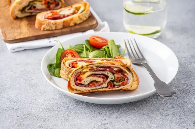Pizza roll stromboli avec fromage, salami, épinards et poivron rouge