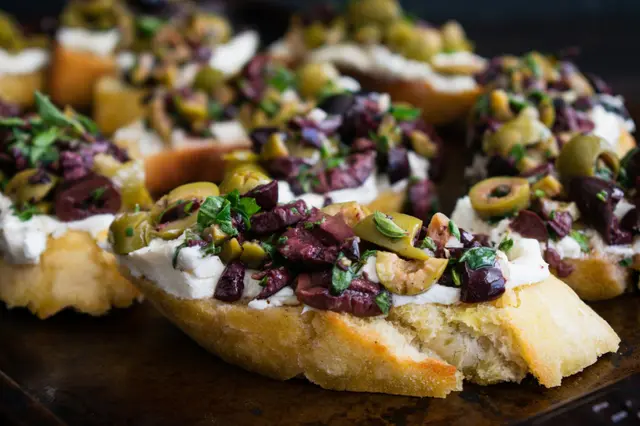 Tapenade aux olives aux herbes sur bruschetta au fromage de chèvre