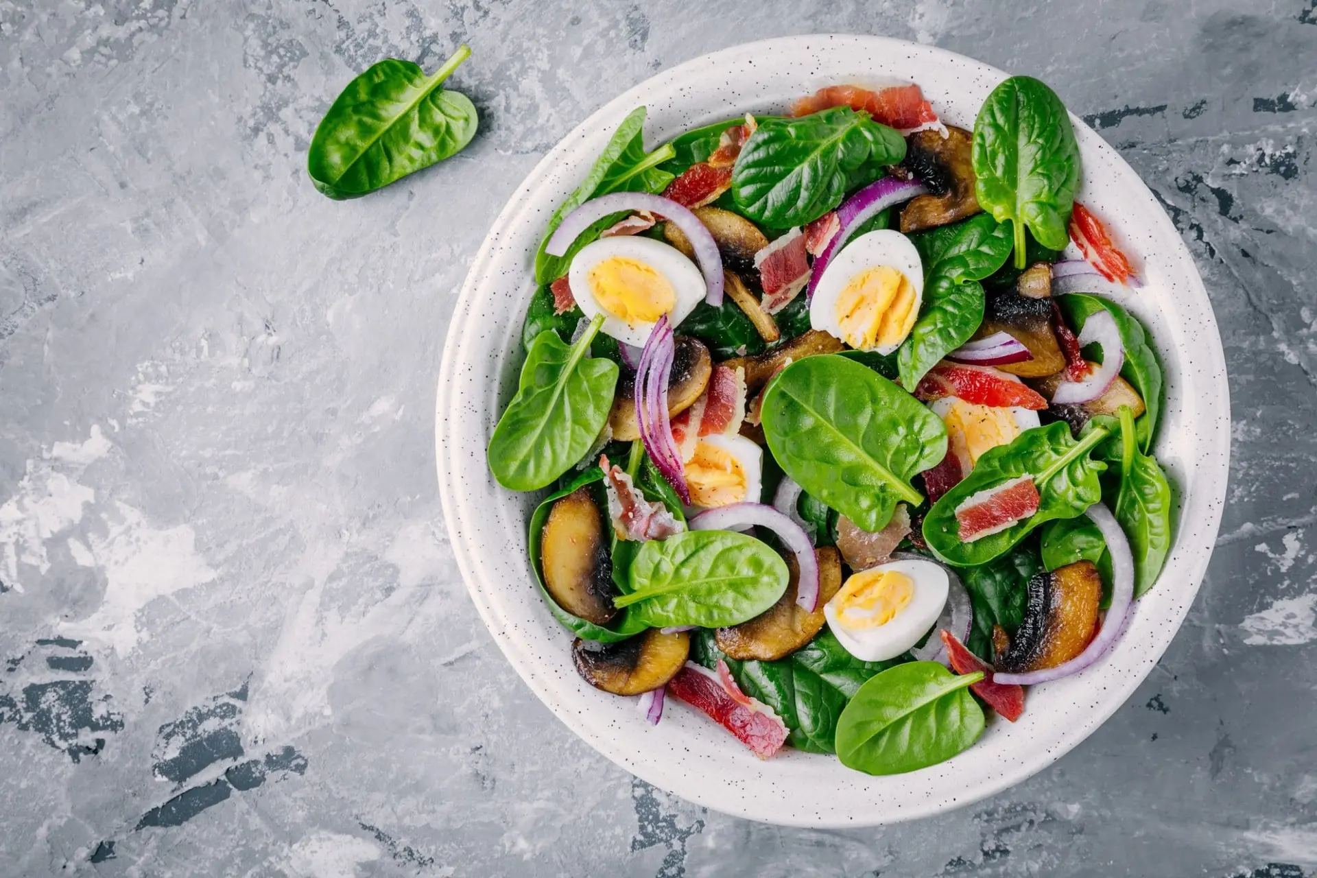 Recette de salade d'épinards avec oeufs, bacon, champignon et oignons rouges