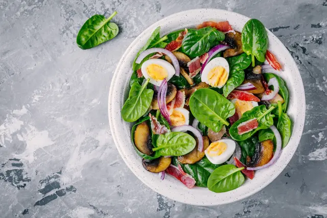 Recette de salade d'épinards avec oeufs, bacon, champignon et oignons rouges
