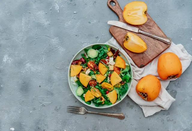 Salade de roquette, kakis, noix et légumes croquants