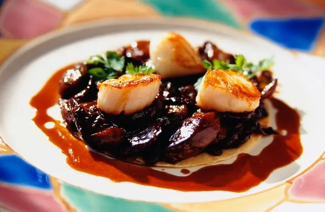 Coquilles Saint-Jacques frites sur un lit de cèpes, avec sauce