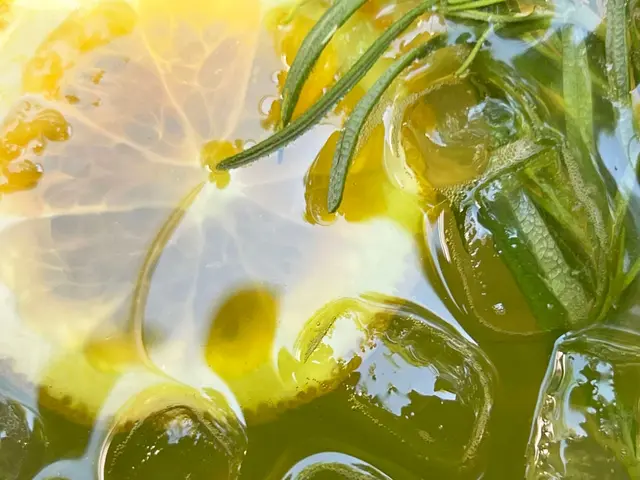 Thé vert détox froid avec tranches de citron, glaçons et feuilles de romarin