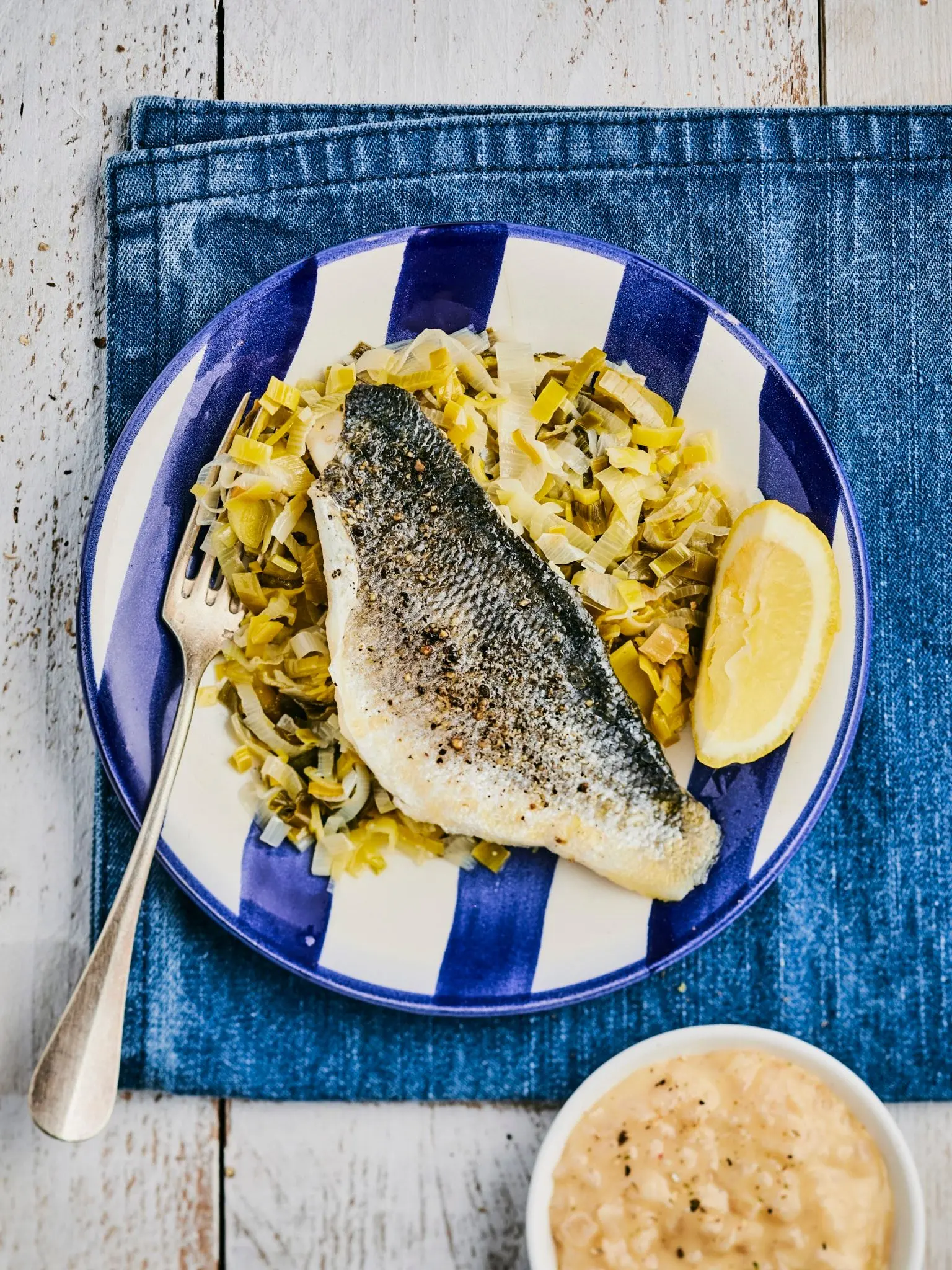 Filet de bar au beurre citronné sur un lit de poireaux