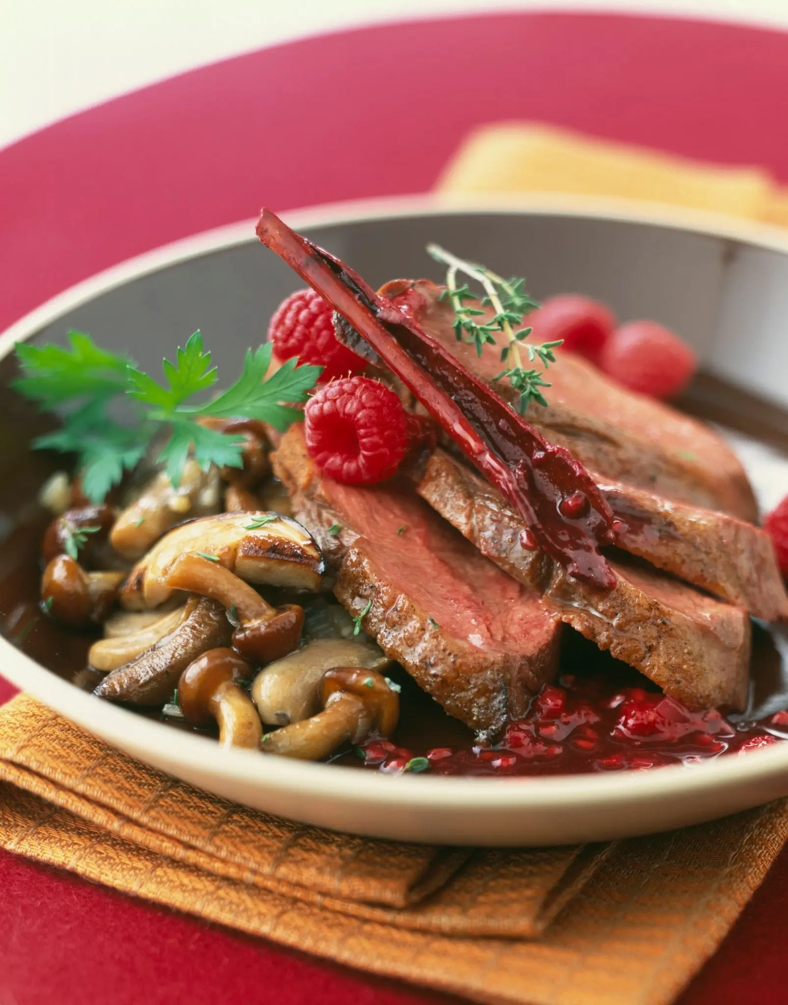 Magret de canard rôti, sauce aux framboises et poêlée de champignons