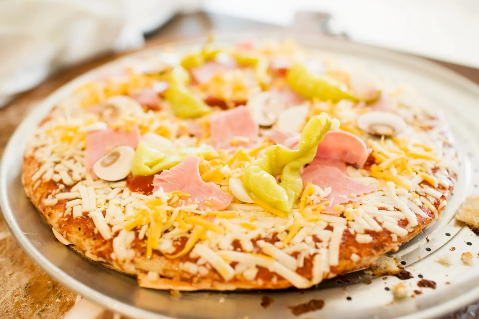 Pizza au jambon, aux champignons, aux poivrons à l'emmental et au cheddar
