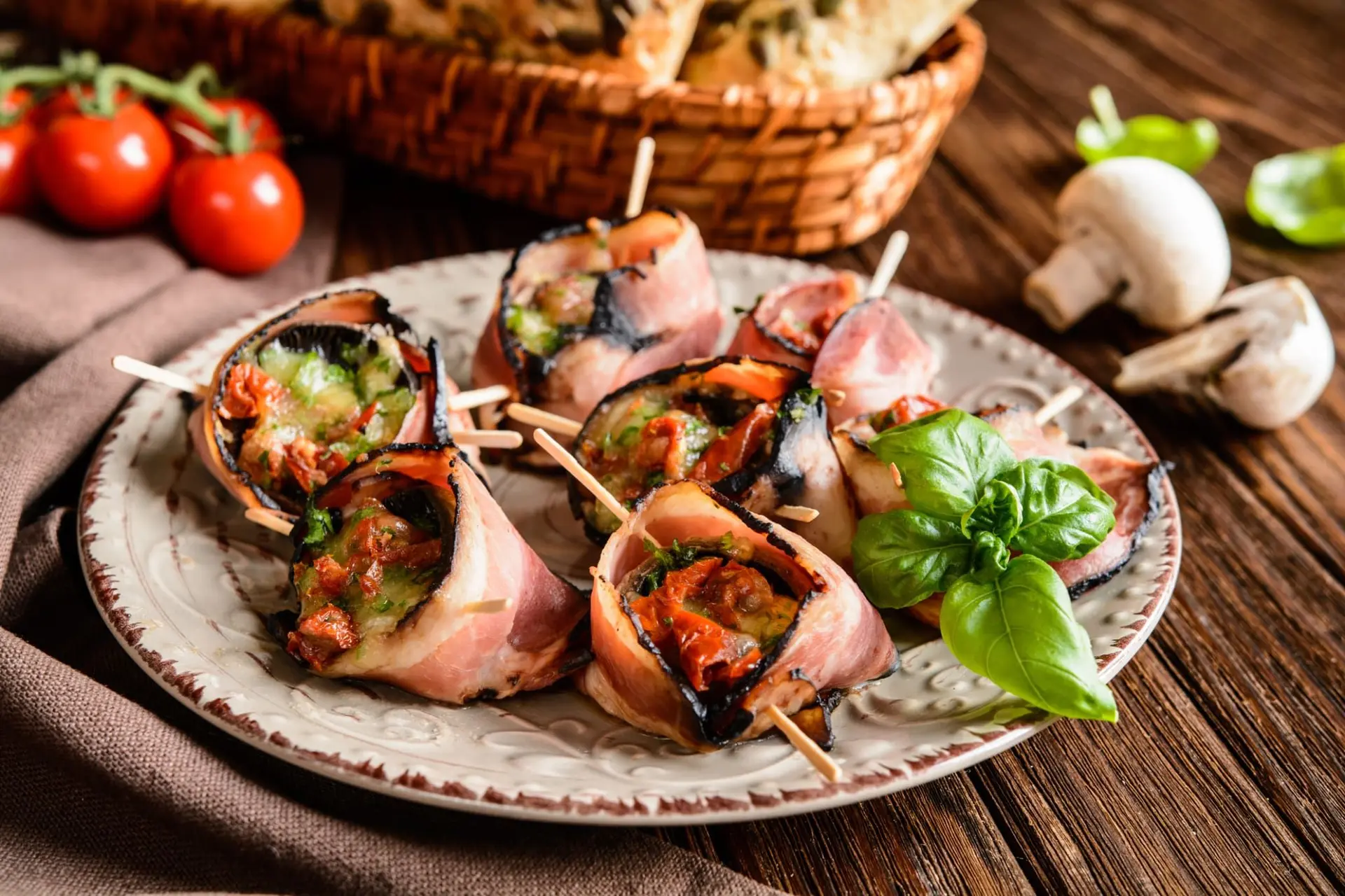 Champignons farcis au fromage, tomates séchées enveloppés dans du bacon