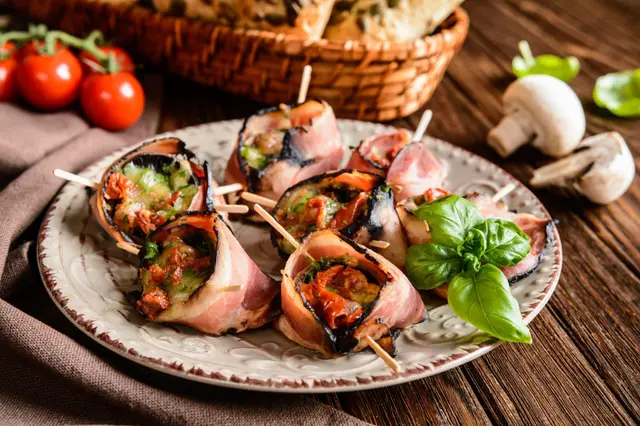 Champignons farcis au fromage, tomates séchées enveloppés dans du bacon