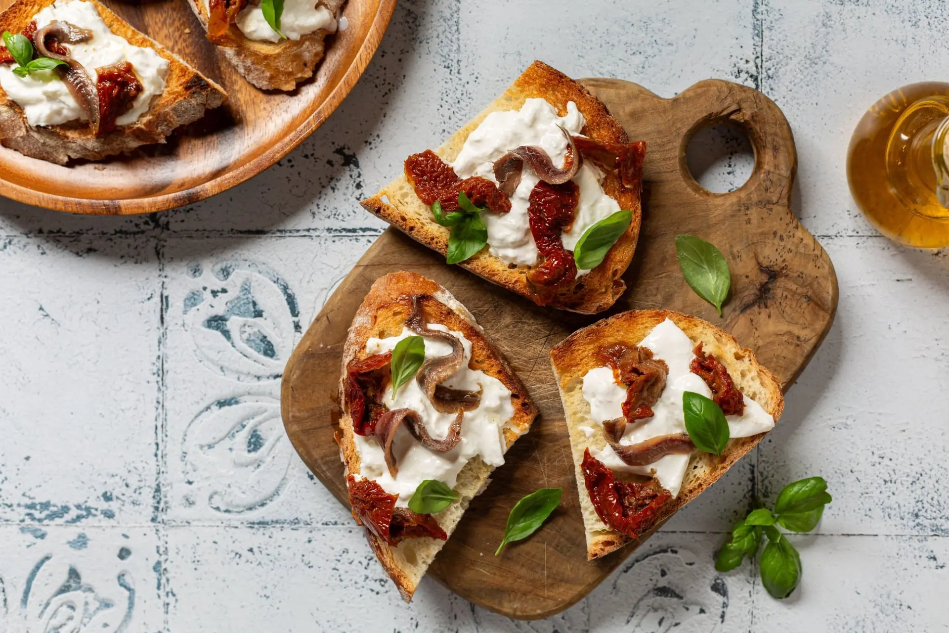 Crostini à la tomate séchée, anchois, basilic et burrata
