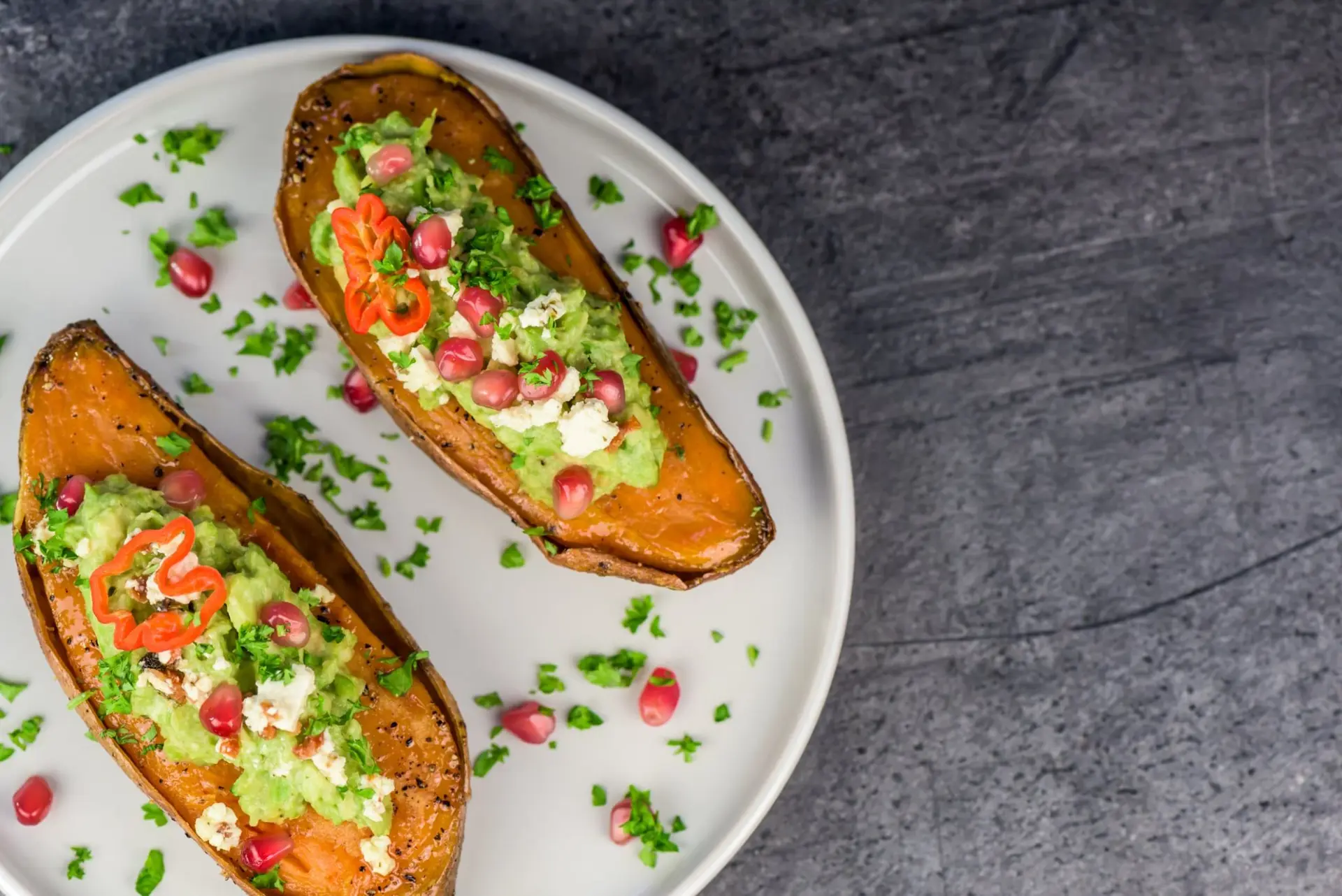 Patates douces au four avec guacamole, feta et grenade