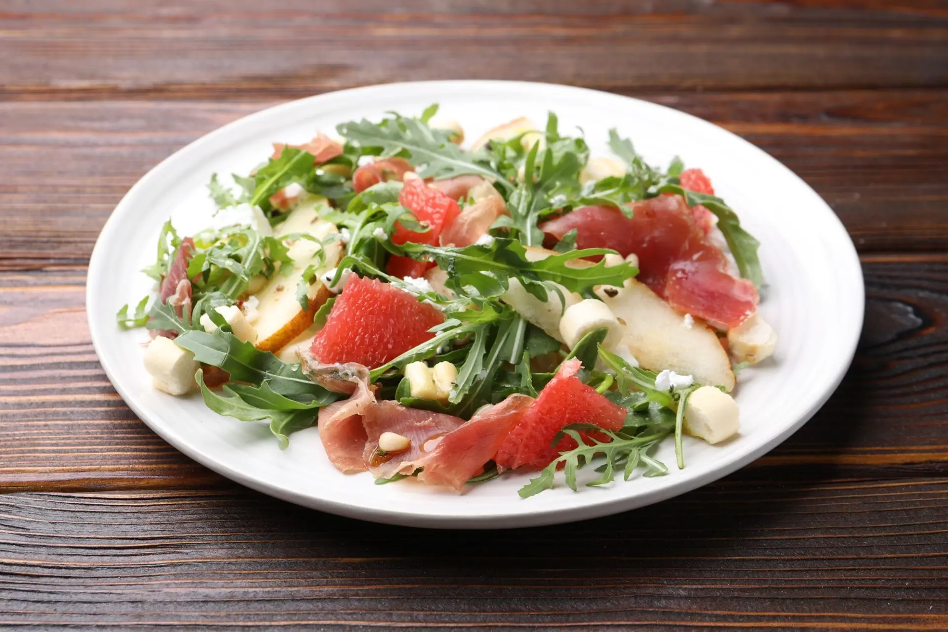 Salade de roquette avec prosciutto, fromage, poire, pamplemousse et noix