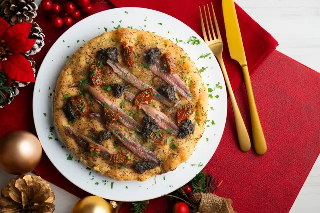 Focaccia italienne authentique aux anchois salés, tomates séchées et olives noires