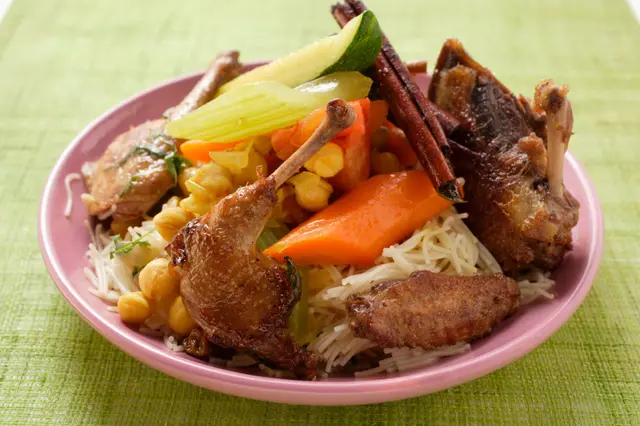 Pigeon rôti aux légumes et bâtonnets de cannelle sur des nouilles