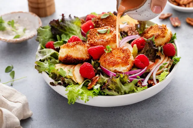 Recette de salade au chèvre frit, pomme et framboises à la vinaigrette avec oignons rouges