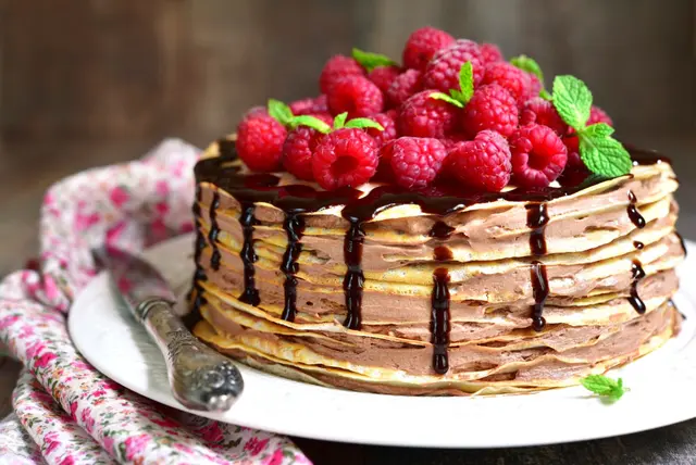 Gâteau de crêpes au chocolat parsemé de framboises